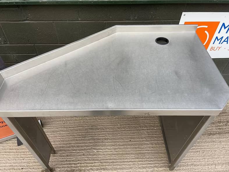 Angled top stainless steel table with splash guard